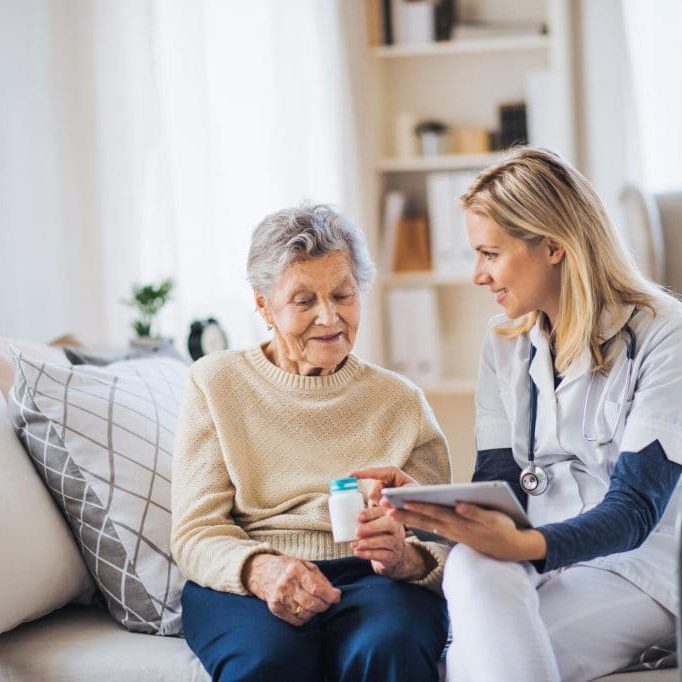 A,Health,Visitor,With,Tablet,Explaining,A,Senior,Woman,How